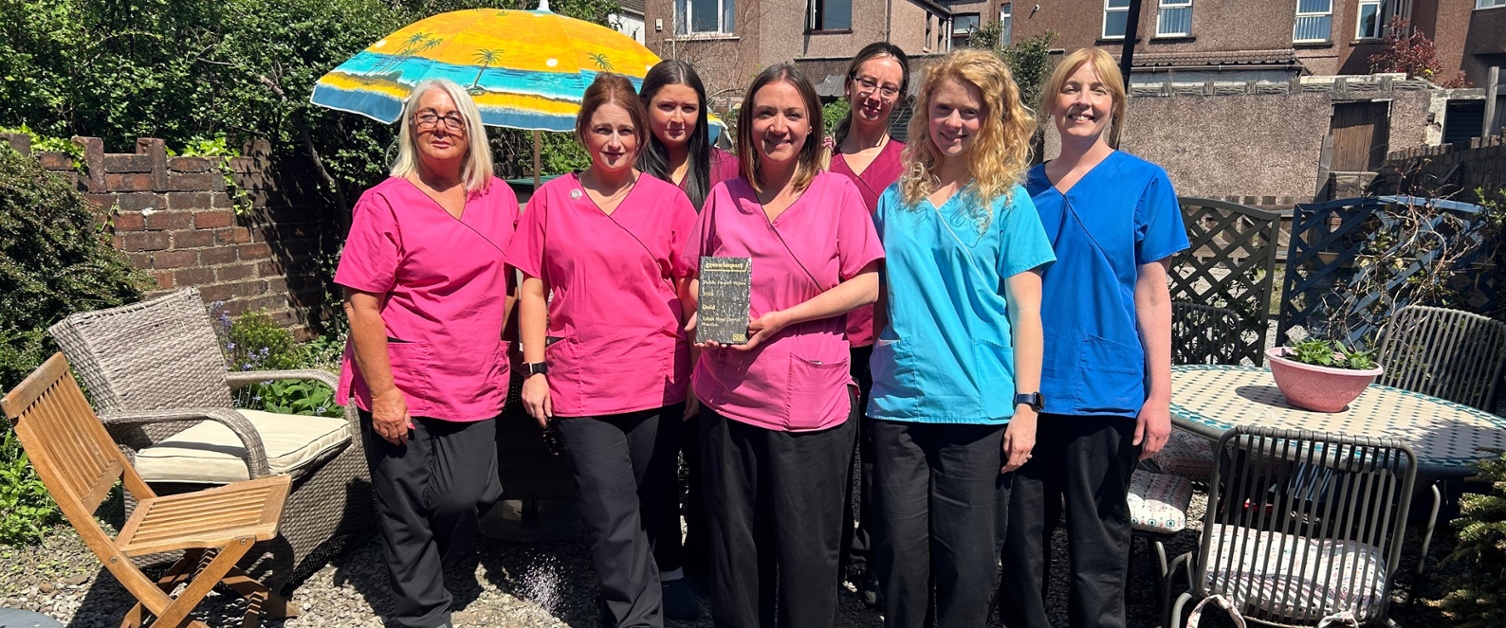The Talbot Road Dental team stood in their garden with an award
