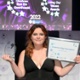 Image shows a young woman with awards at an award ceremony