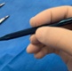 Image shows a hand holding a surgical instrument.