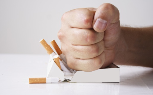 Picture shows a clenched fist crushing a packet of cigarettes.