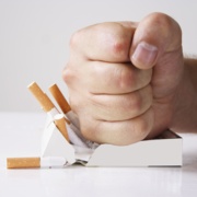 Picture shows a clenched fist crushing a packet of cigarettes.