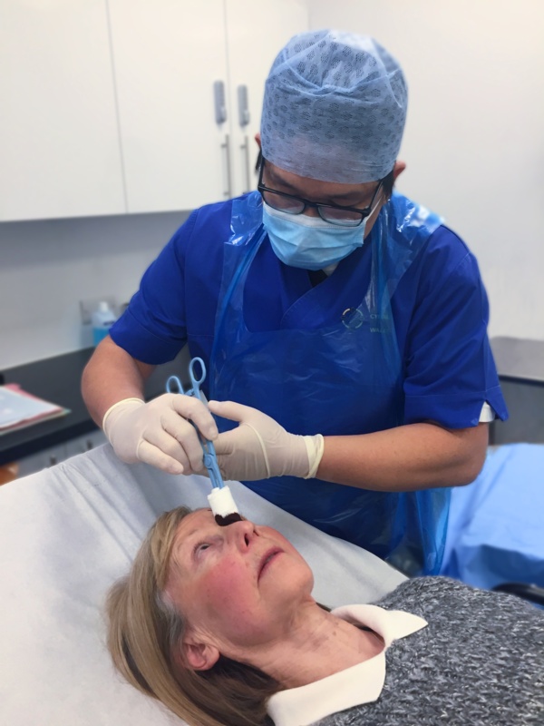 Nurse carries out eye procedure on patient