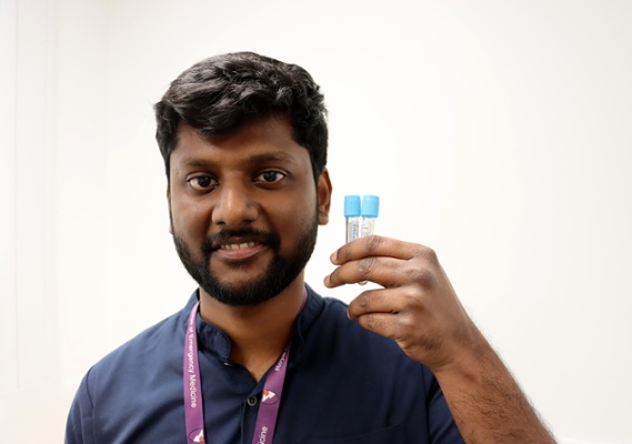 Image shows a man holding a bottle