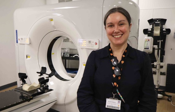 Image shows a clinician in a radiotherapy treatment room.