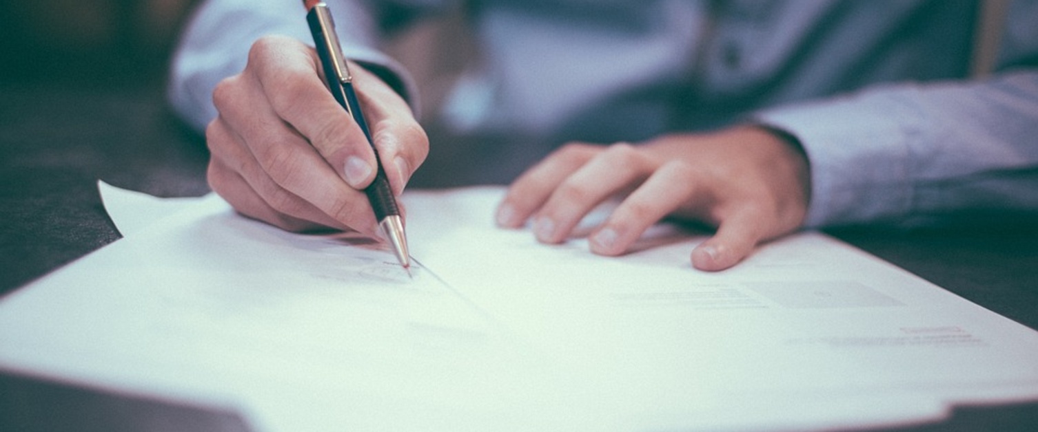 Man writing on white paper.