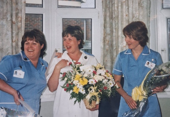 Image shows three women holding flowers