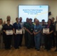Hospital staff pictured holding award certificates, with patients next to them