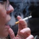 A close up of a woman in profile smoking a cigarette