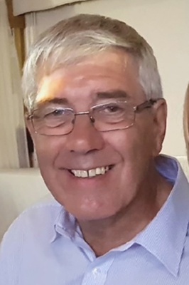 Image shows a smiling middle-aged man.