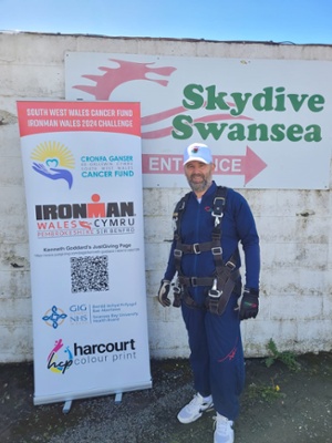 Image shows a man standing in front of a sign