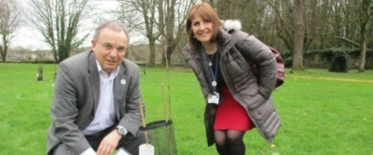 Chairman Andrew Davies and Rena Owen standing in a garden by a plant.