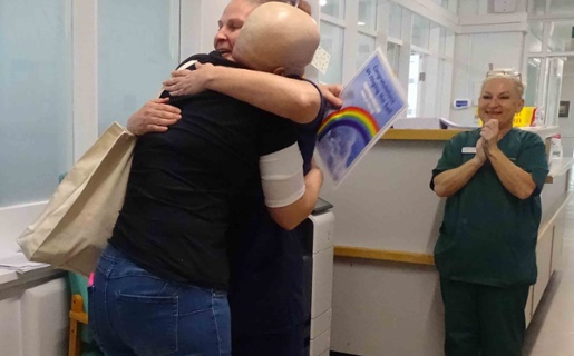 Image shows a patient hugging a hospital nurse.