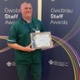Steve wearing his uniform and holding his award certificate