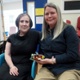 Julia is holding the Lego model. She is sat next to Maura.
