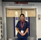 Image shows a woman standing outside double doors