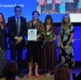 Image shows people on stage at an awards ceremony.