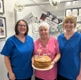 Angela holding a cake with Janette and Ann-Marie