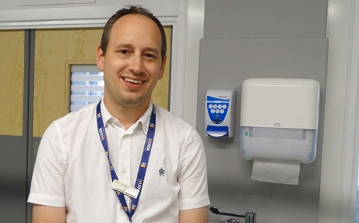 Image shows a doctor smiling into the camera.