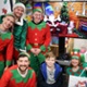 Image shows people dressed as elves with a young hospital patient.