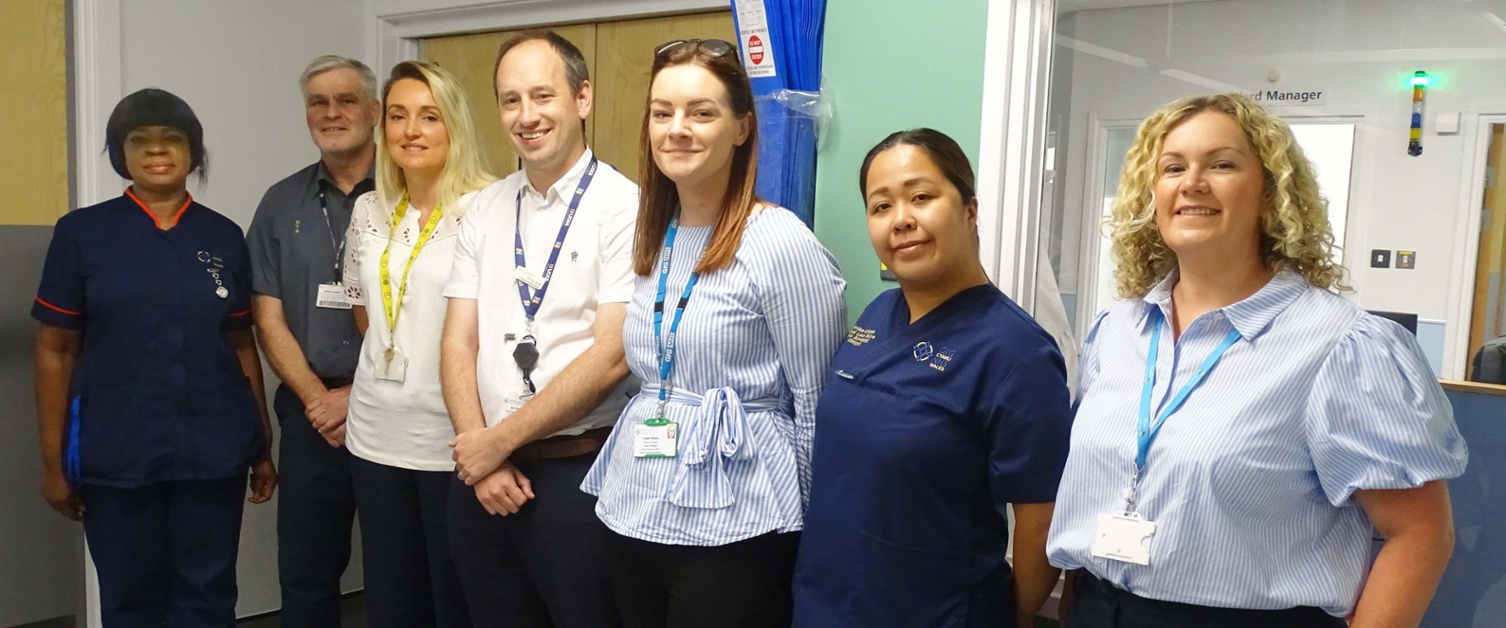 Image shows a group of clinicians in a hospital room.