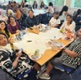 Image shows a group of people sat around a table