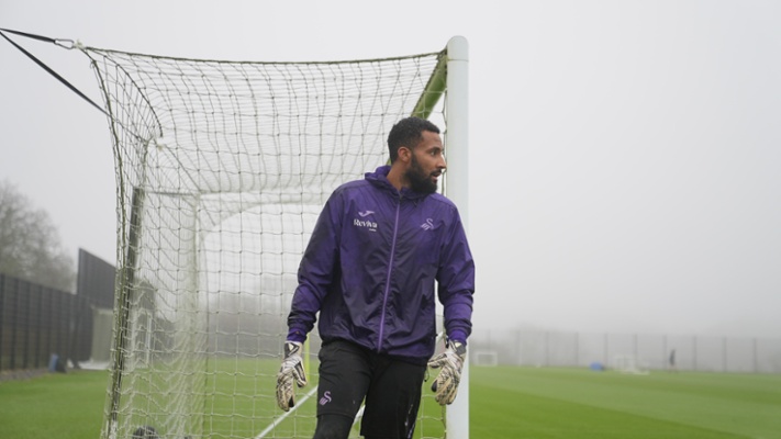 Image shows a man standing in front of a football net