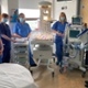 Image shows staff standing around a specialist neonatal device