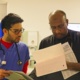 Two male doctors looking over files.