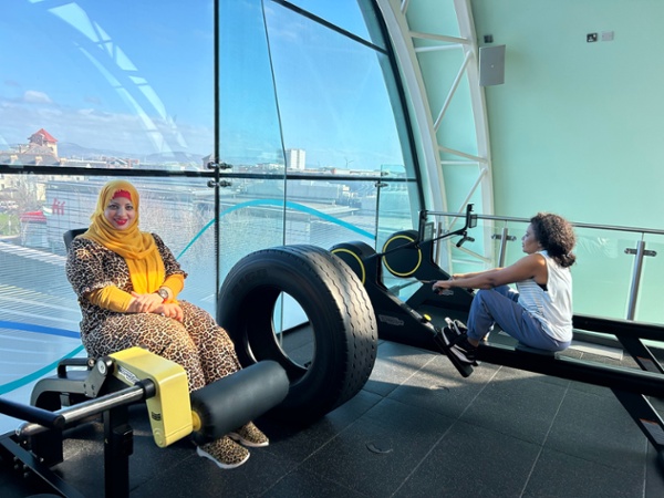 Two women using gym equipment