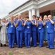 Image shows a large group of nurses in uniform making a heart shape with their hands.