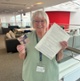 Image shows a woman holding a paper document