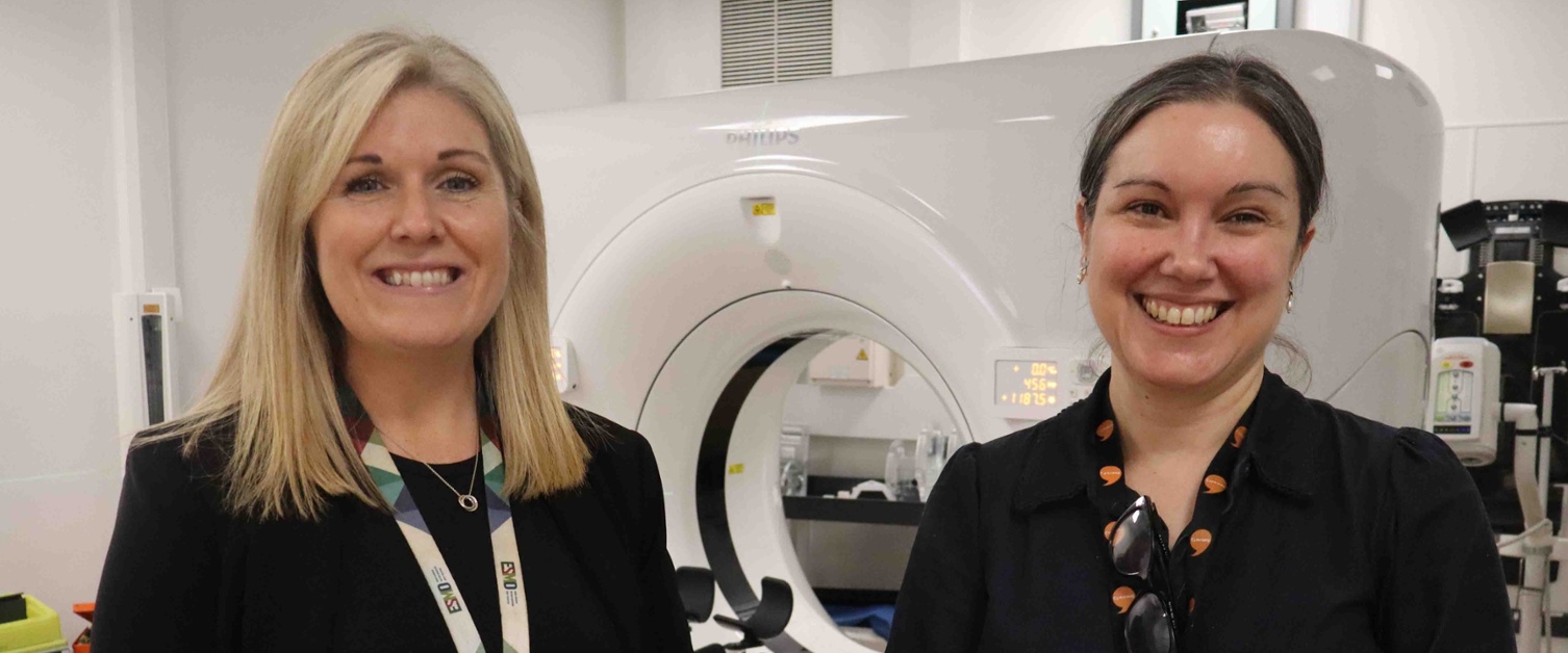 Image shows two clinicians in a radiotherapy treatment room