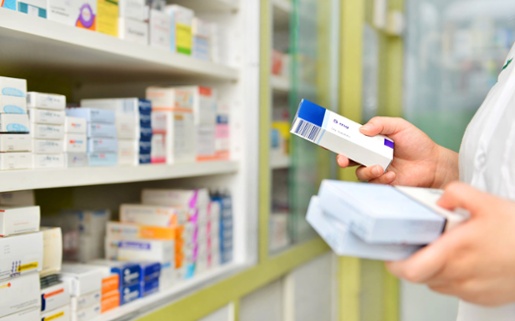 A pharmacist looking at a box of tablets