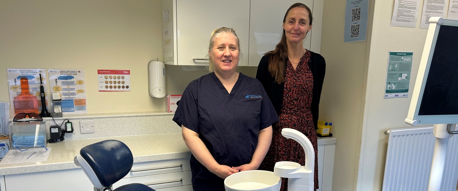 Lois with Elizabeth stood next to a dental chair