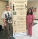 Image shows two women standing next to a banner