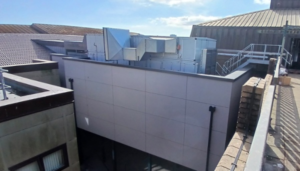 A large building extension, squeezed between two buildings