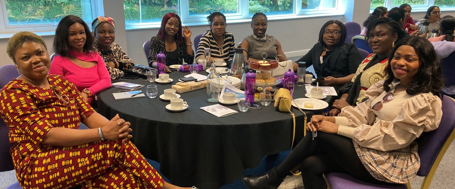 Image shows a group of people sat around a table