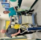 Image shows two men in a hospital corridor standing behind a machine and gas cylinder