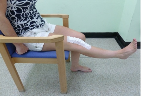 A patient sitting on a chair has their right leg straight out in front of them.