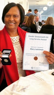 Image shows a woman holding a certificate