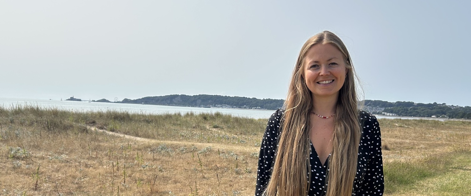Jordanne stood near the beach with Mumbles in the background