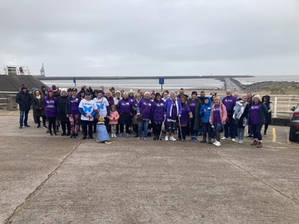 A group of people stood near a beach