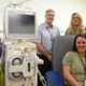 Image shows a group of people gathered around a dialysis machine.