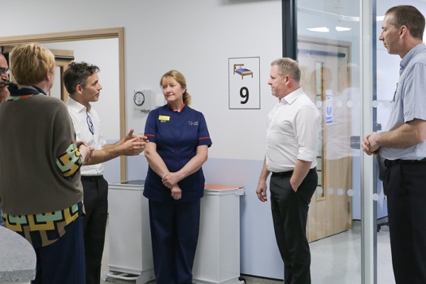 A doctor explaining something to a politician while a nurse looks on