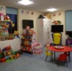The p[layroom at Morriston Hospital showing toys, a book case, TV screen and table and chairs.