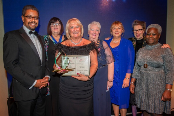 Nurse of the year Jean Saunders stands with her RCN awards. She is joined by five ladies in evening dress and Welsh health minister Vaughan Gething.