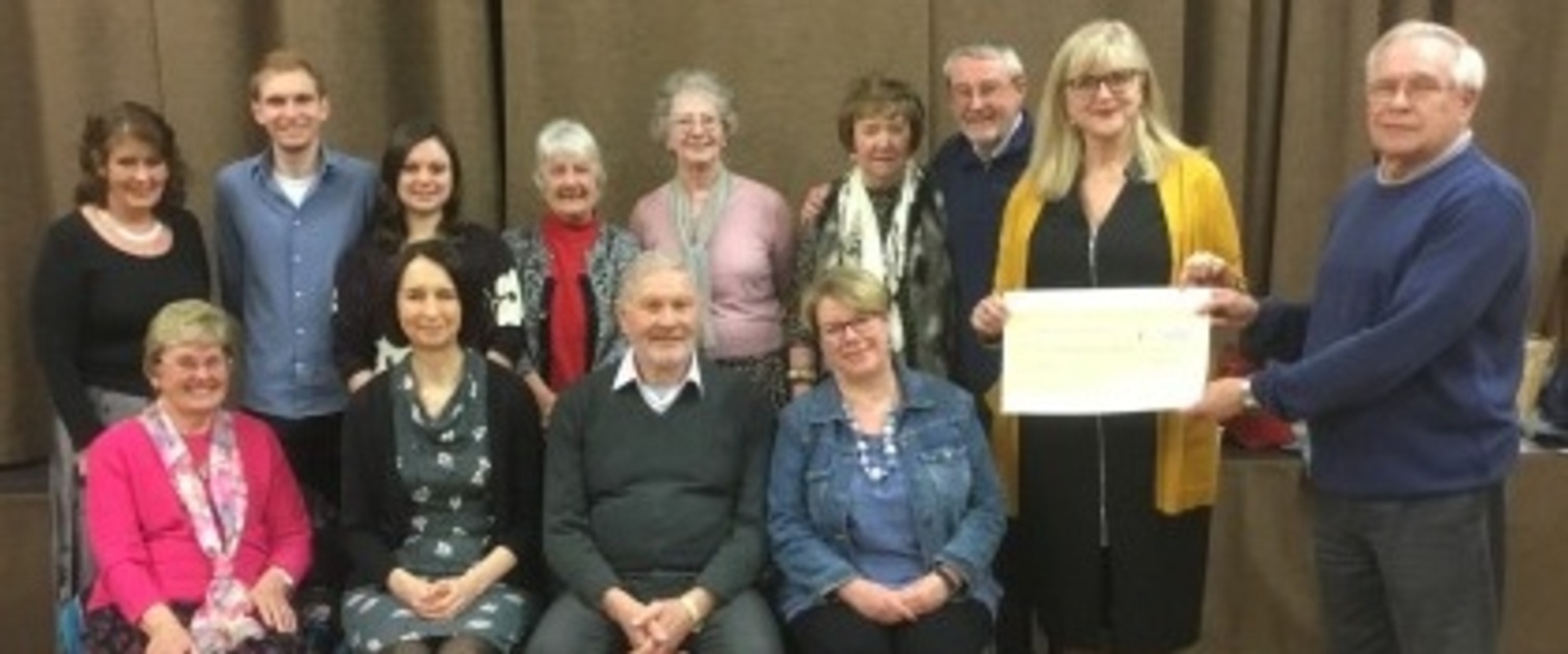 The congregation of a Swansea church presents a cheque to the staff of Ty Grangoch