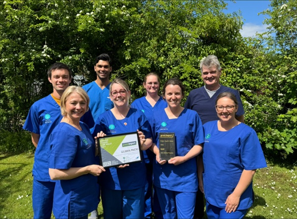 The GCG Dental team stood outside holding an award