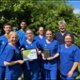 The GCG Dental team stood outside holding an award