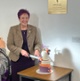 Image shows a women cutting a cake